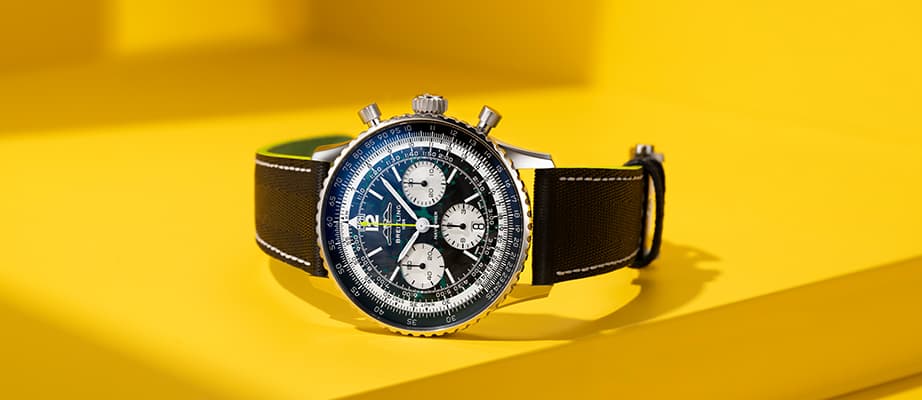 {generated} 青い文字盤と磨かれたスチールブレスレットのブレイトリング ナビタイマー オートマチック GMT 41 侍 日本限定を手首に着用