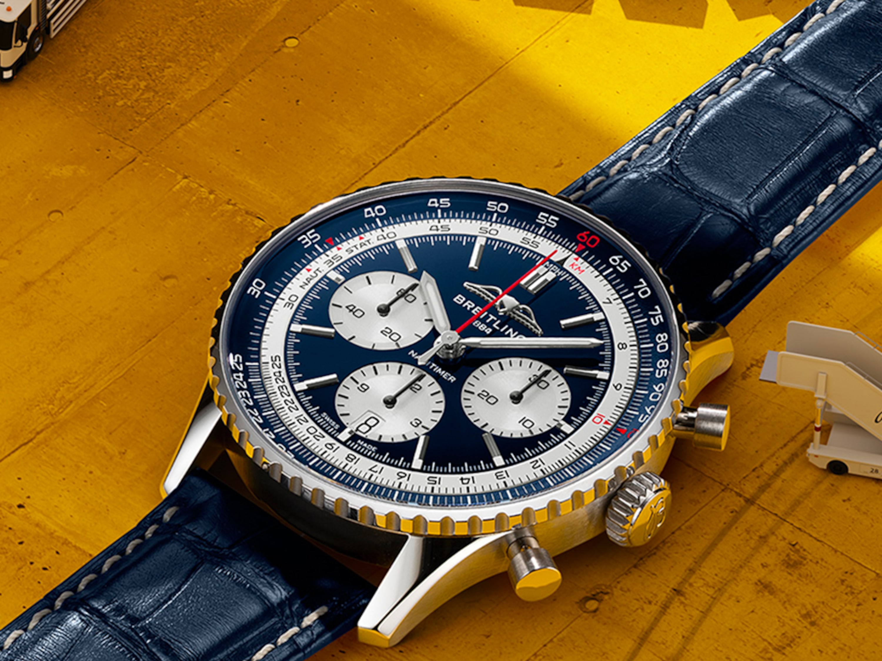 淺藍色錶盤的 Navitimer 和黑色錶盤的 Navitimer 放在桌上。