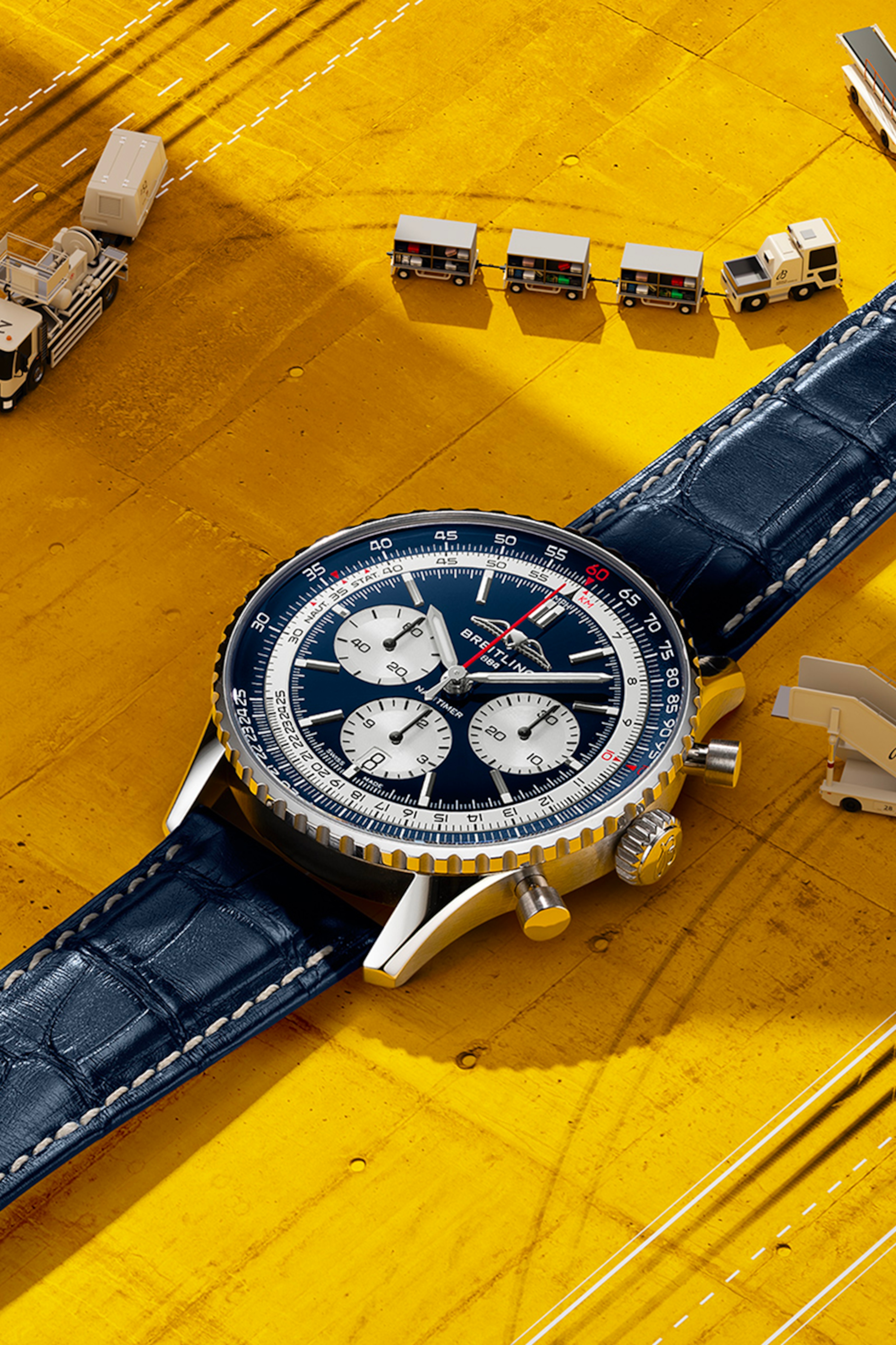 淺藍色錶盤的 Navitimer 和黑色錶盤的 Navitimer 放在桌上。