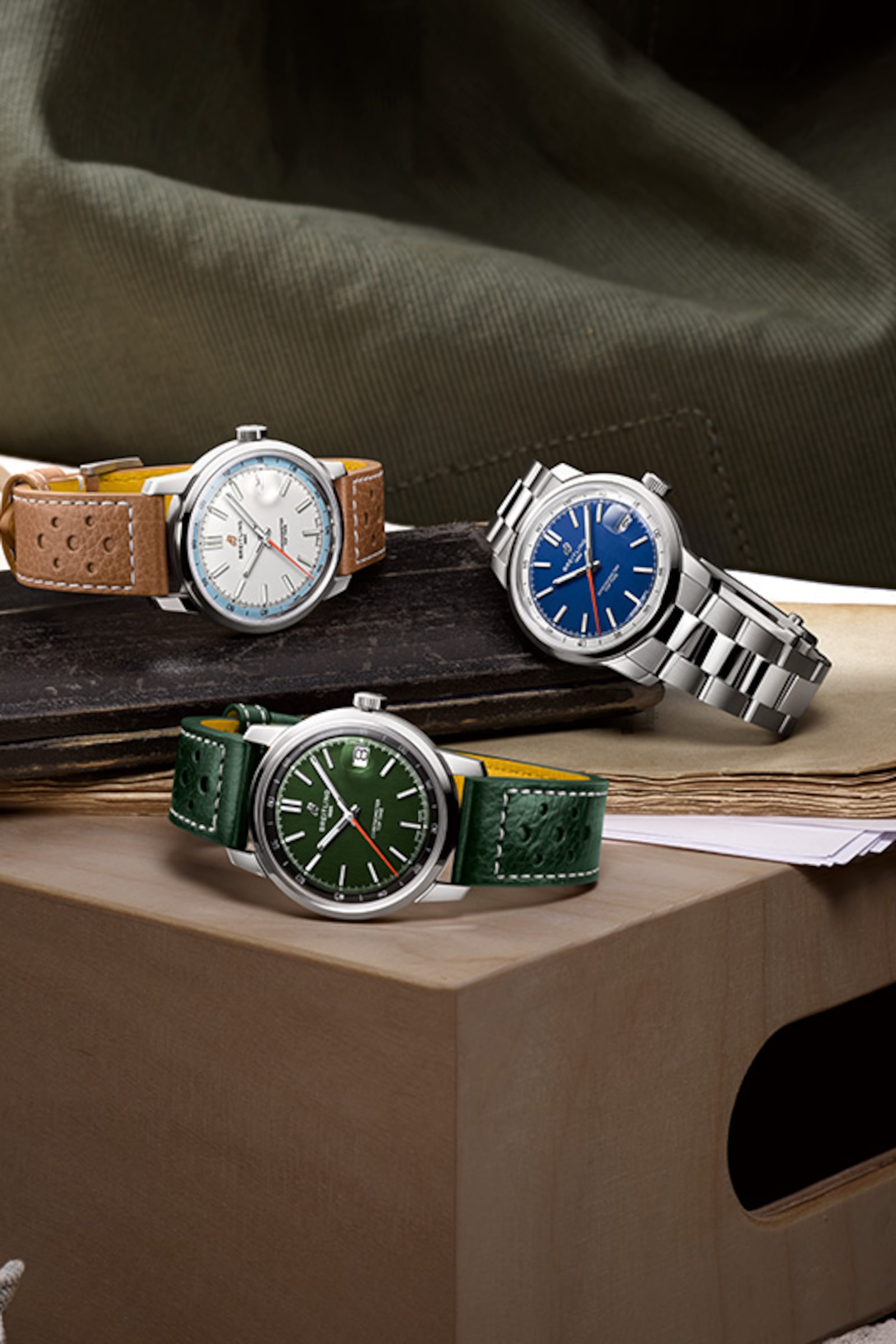 Three Top Time watches with different colored dials and straps on a shiny background.