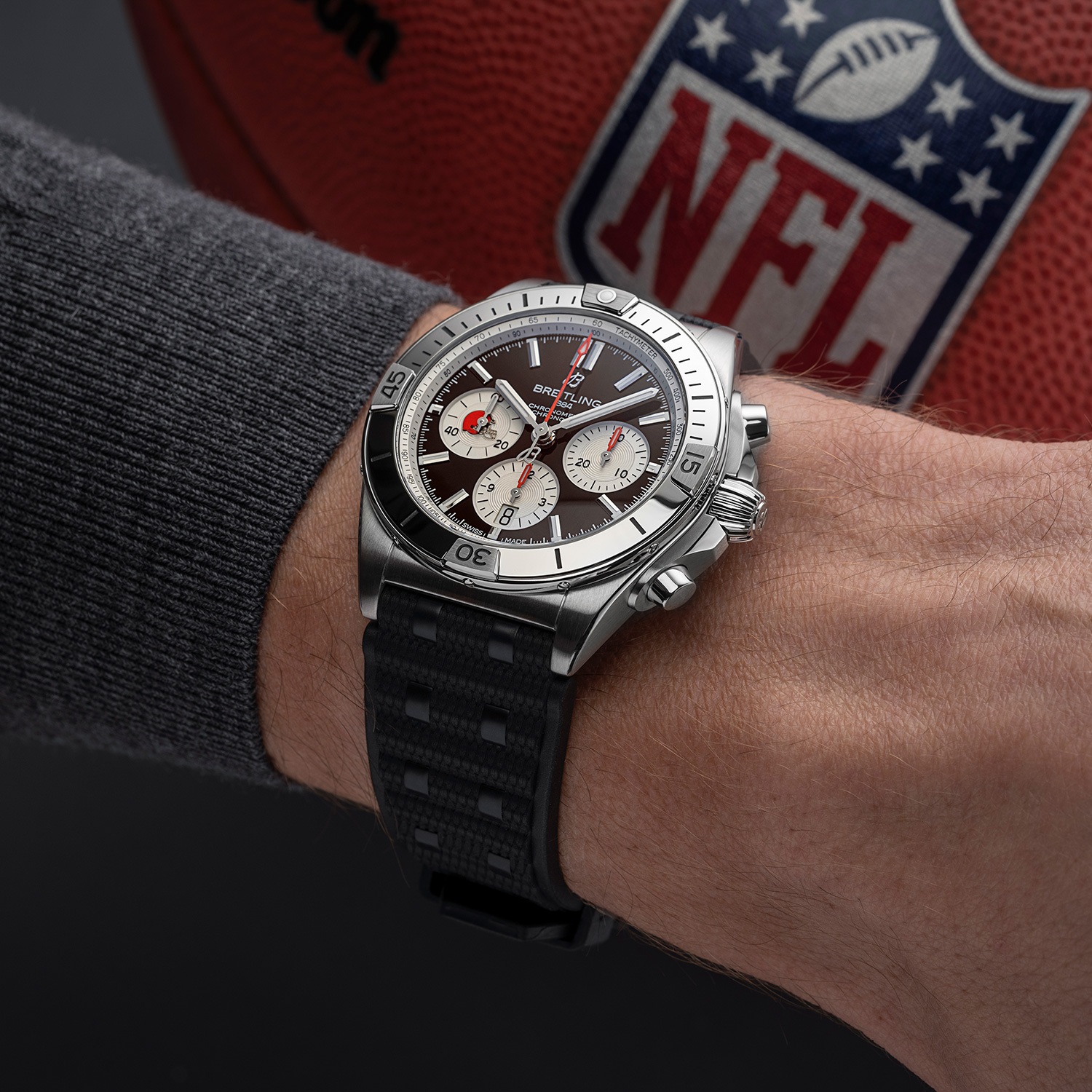 A watch from the limited NFL collection with a black dial on a glossy surface.