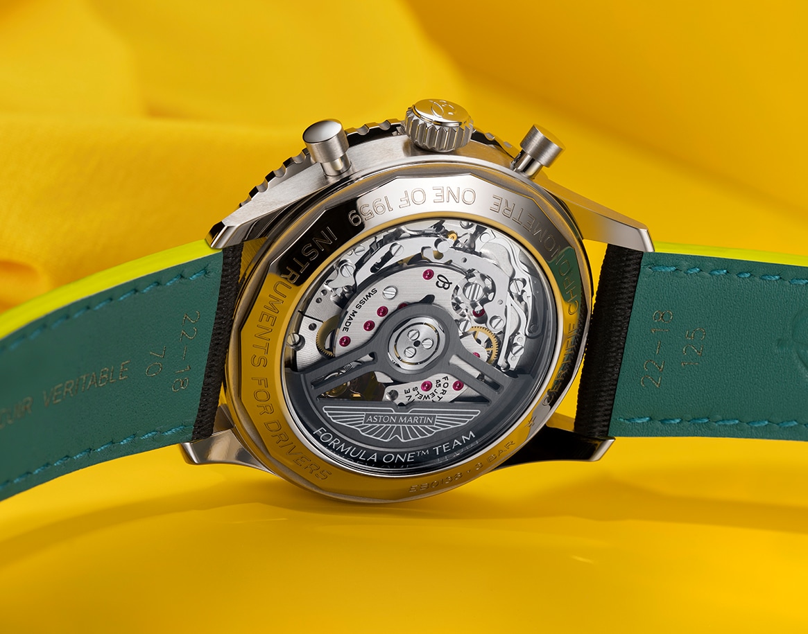 {generated} Breitling Navitimer watch with black strap and refined chronograph dial set against a vivid yellow fabric backdrop.
