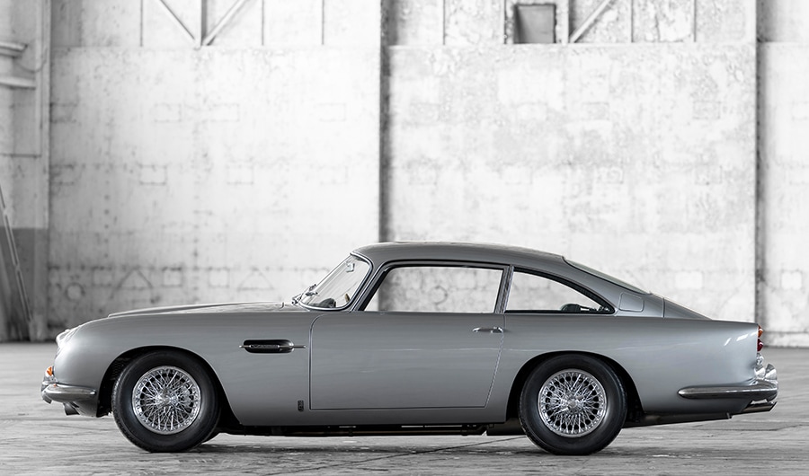 {generated} Sleek grey Aston Martin sports car with red accents displayed under lighting to represent its Breitling partnership.