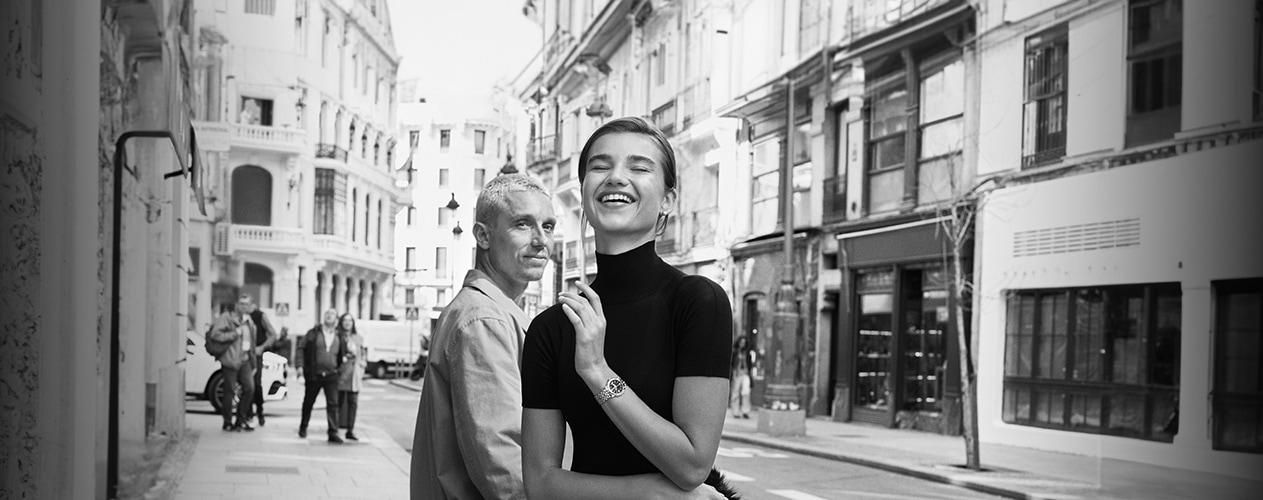 {generated} Breitling gift-wrap scene with a navy box, branded paper, yellow ribbon, and scissors arranged on a wooden surface