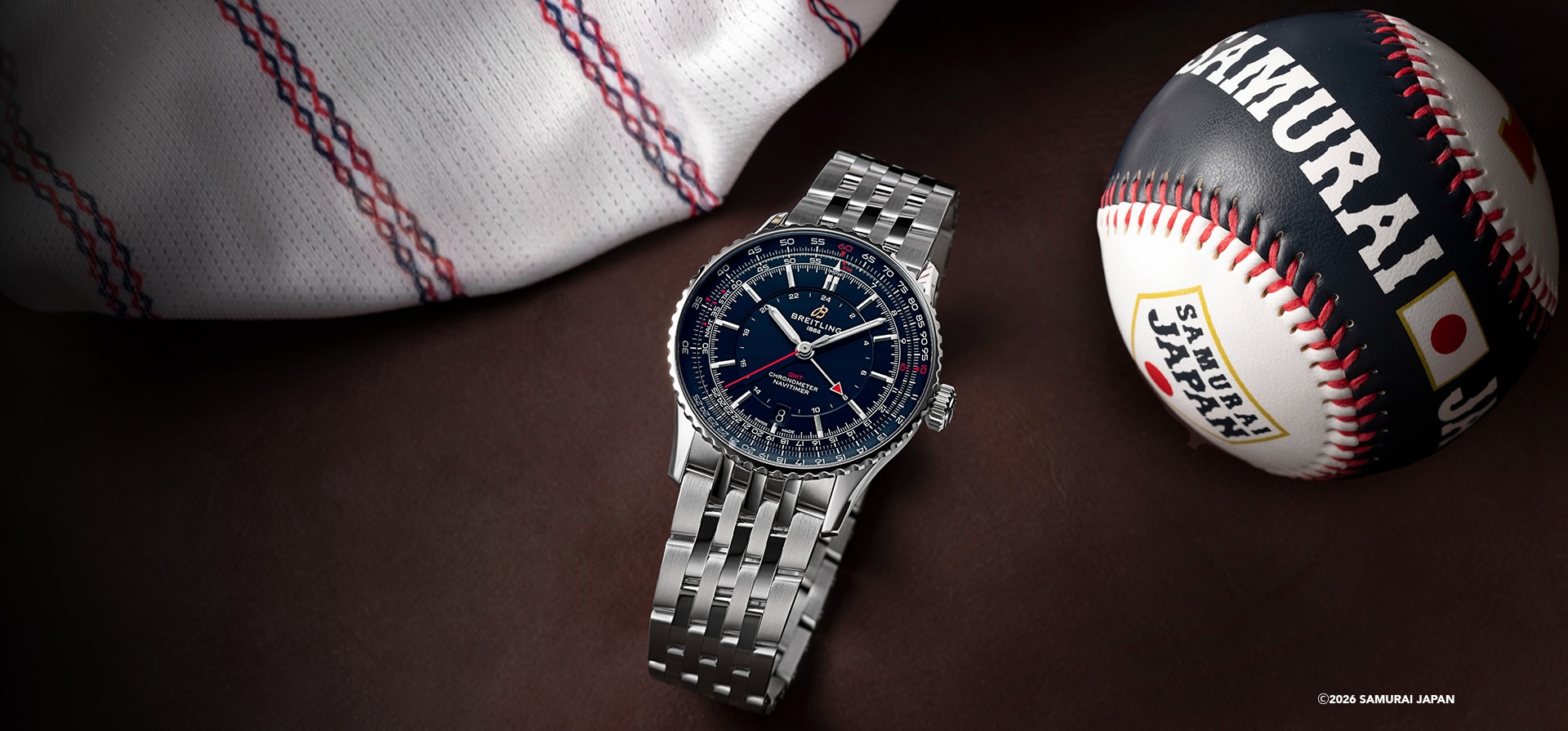 {generated} Breitling Navitimer GMT41がレザー上でユニフォームとサムライジャパンのボールと並び、その力強い個性を際立てる。