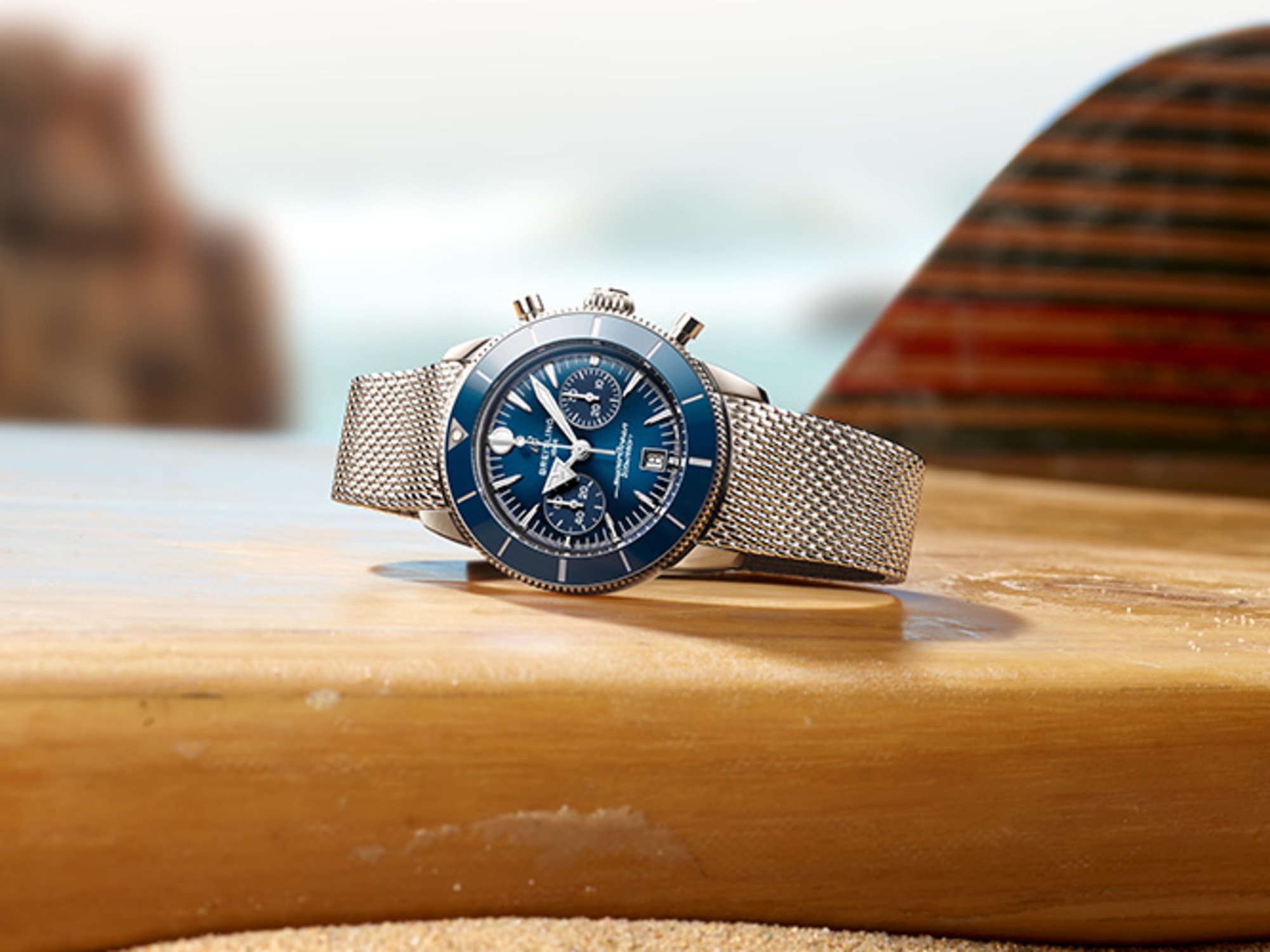 A dark blue Superocean Heritage lies on a table with a magazine and a white rope.