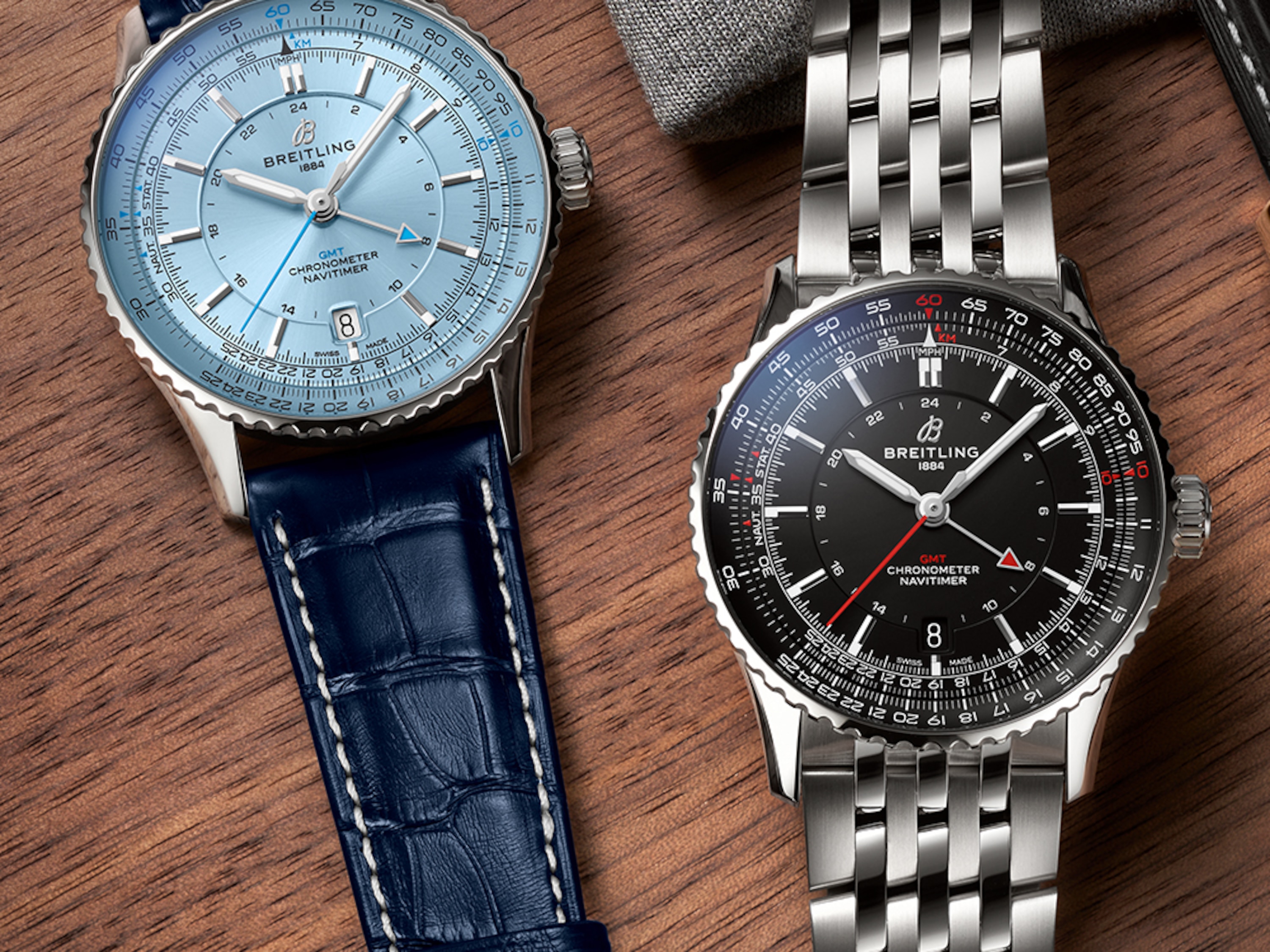 Navitimer con esfera azul claro y Navitimer con esfera negra sobre una mesa.