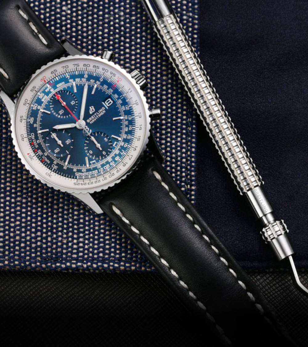 {generated} Breitling Navitimer с синим циферблатом, инструментом для смены и чёрным кожаным ремнём Breitling на фактурной ткани