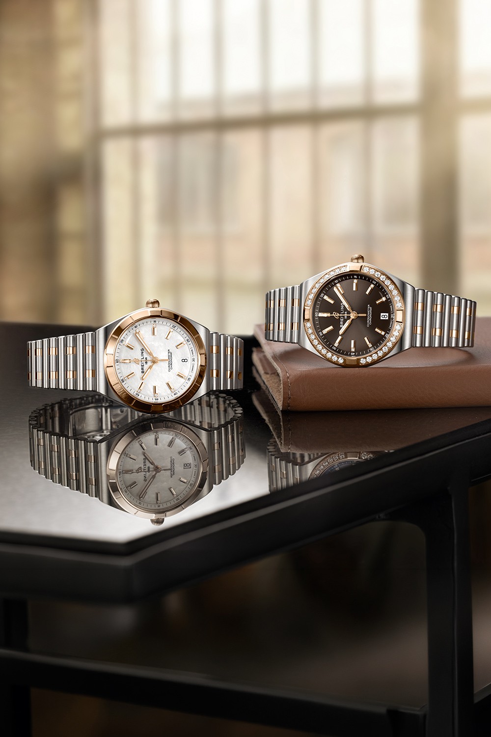 Three silver and three gold Chronomat watches with different-colored dials against a black background.