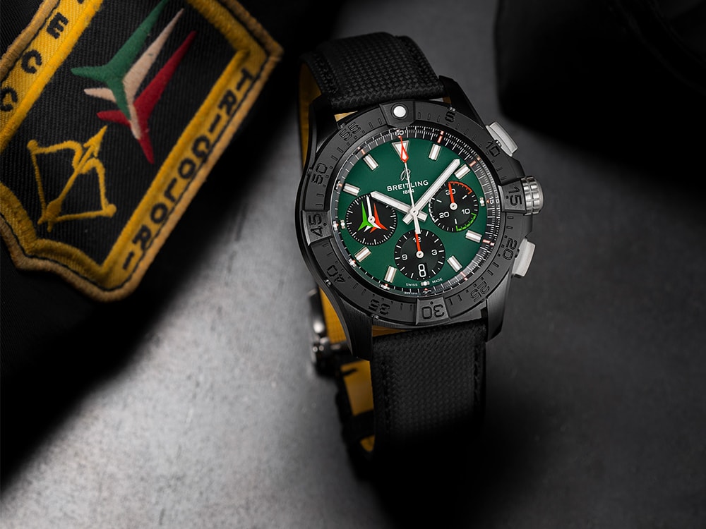 {generated} 緑の文字盤と黒いストラップのBreitling Avenger Frecce Tricoloriが刺繍入り航空パッチのそばに置かれている