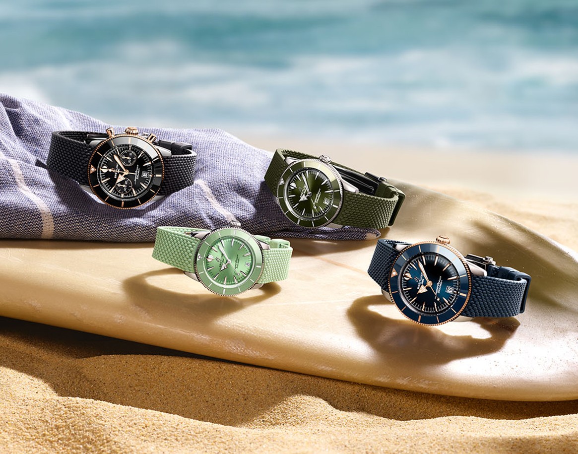 {generated} Surfers walk along a windy beach, with the man wearing a Breitling dive watch emphasising its helium escape valve design
