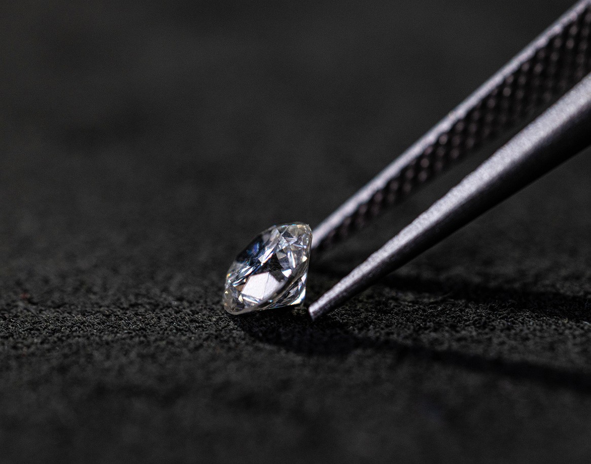 {generated} A polished diamond held by precision tweezers on dark fabric, showcasing the refined materials featured in Breitling craftsmanship