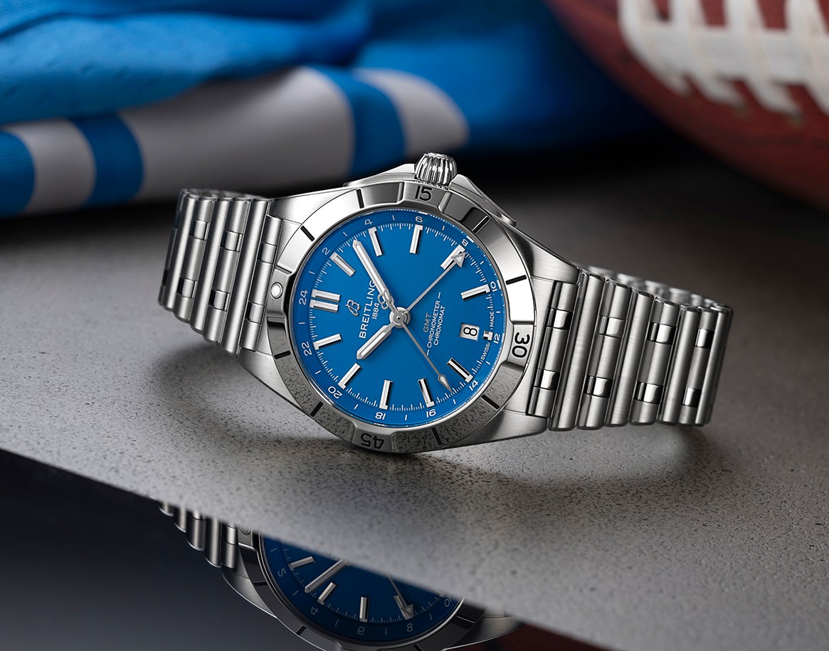 {generated} Breitling Chronomat with blue dial displayed beside Detroit Lions colors and football, highlighting team partnership.