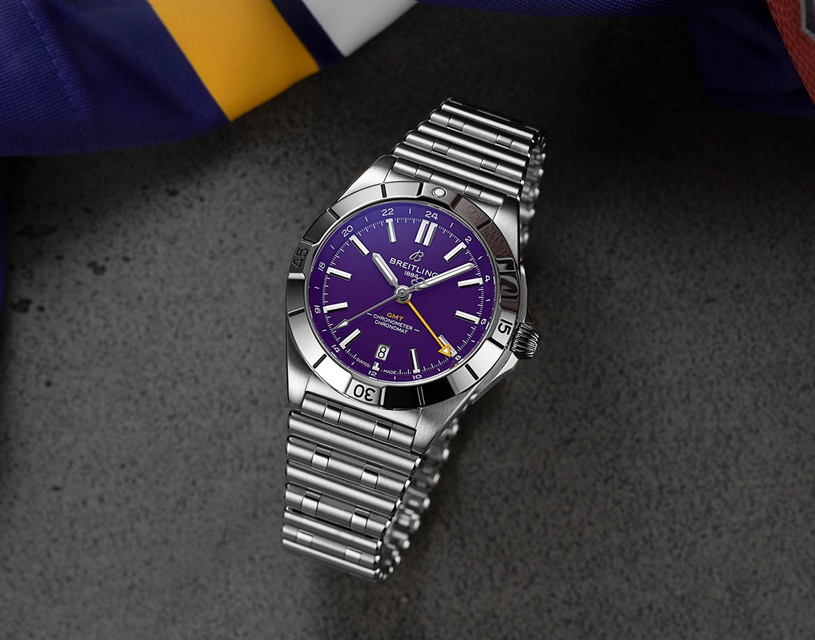 {generated} 百年靈 Chronomat GMT 採明尼蘇達維京人紫色錶盤，置於質感表面並伴隨球隊色彩。