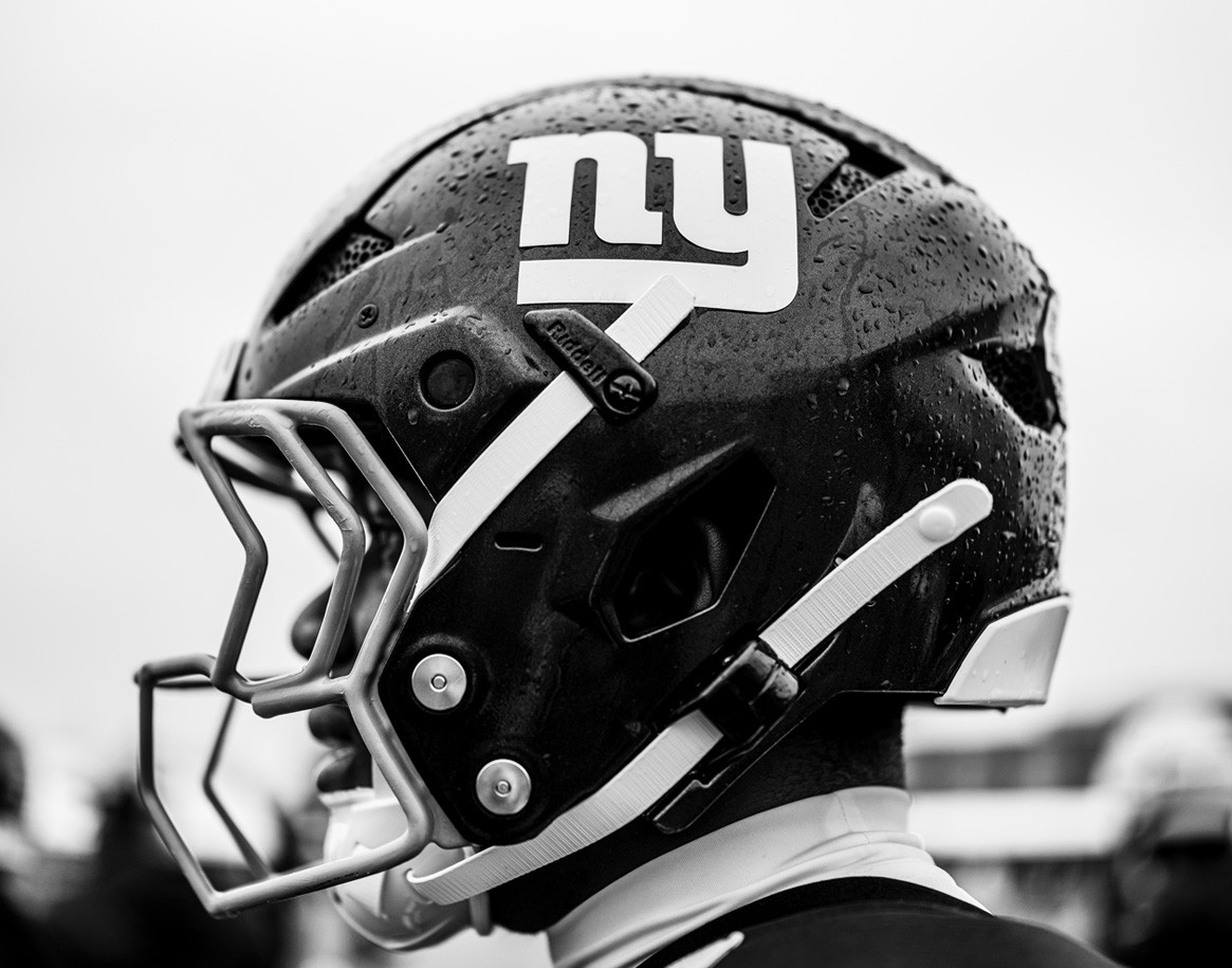 {generated} Breitling watch with blue dial set beside New York Giants gear and an NFL football, emphasising its refined sporting style.