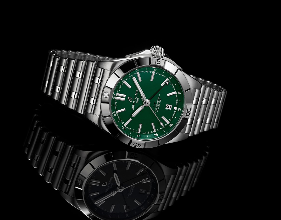 {generated} Breitling Chronomat with green Jets-inspired dial and steel bracelet shown on black surface with refined detail
