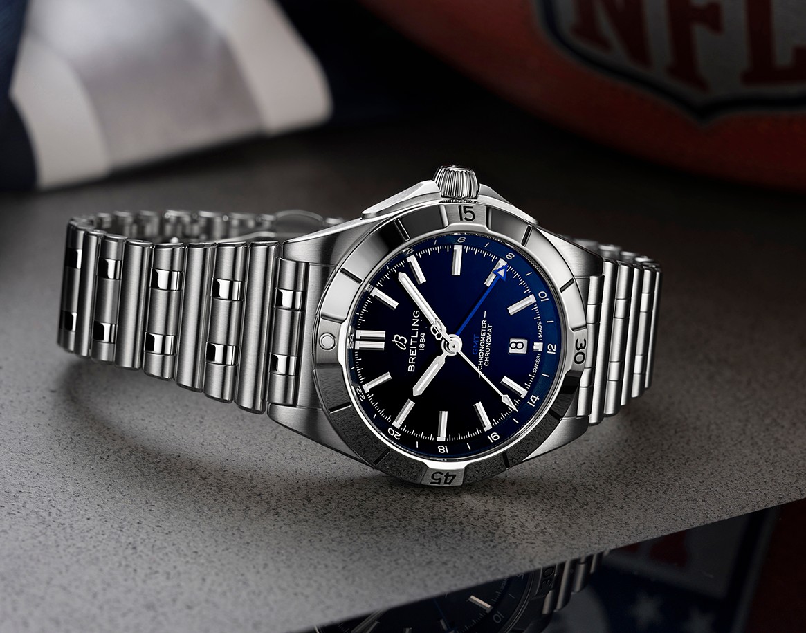 {generated} Breitling Chronomat with blue dial and steel bracelet set beside Dallas Cowboys gear, highlighting sporty refinement