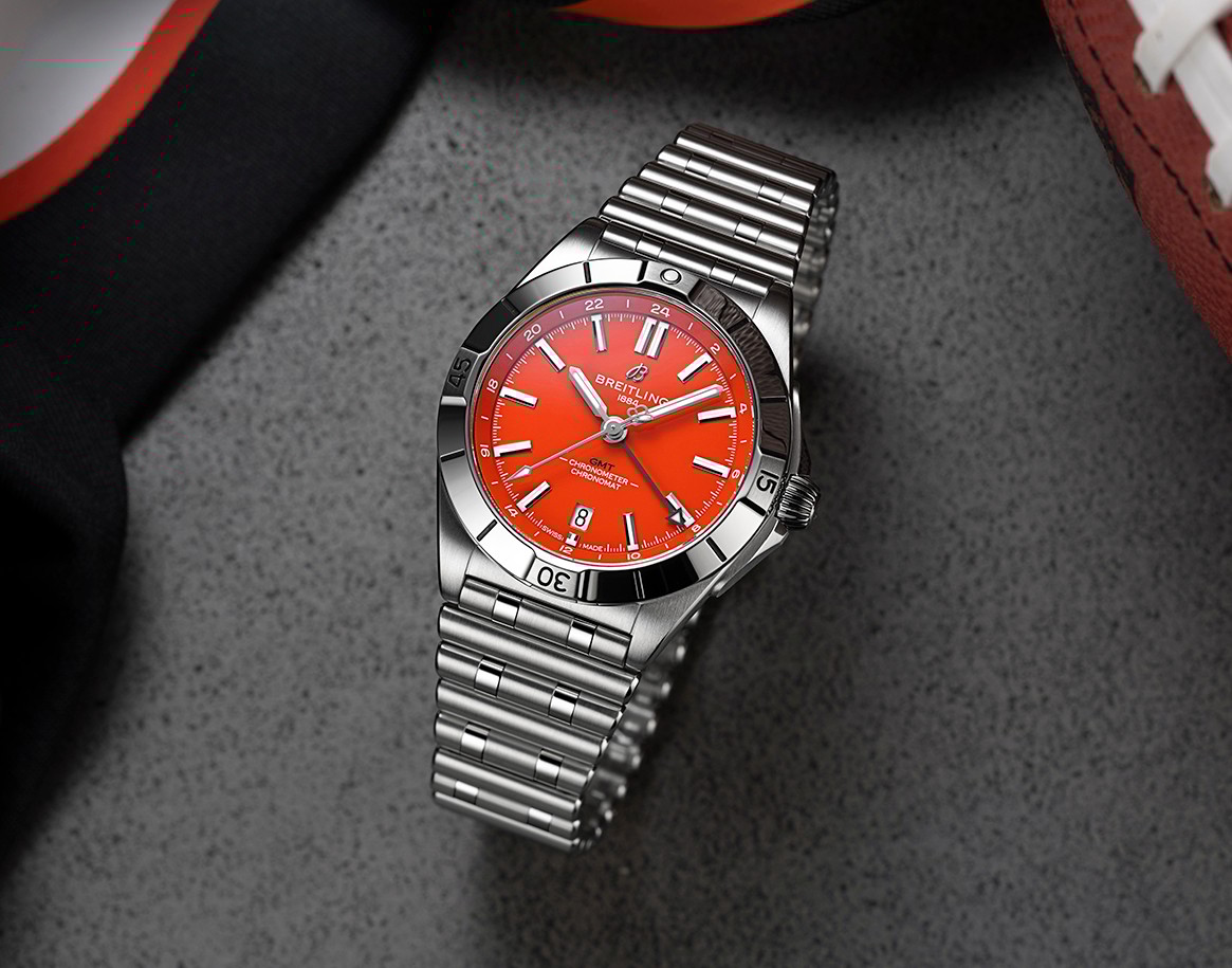 {generated} 採亮橙色錶盤的Breitling Chronomat GMT配鋼鏈，陳列於辛辛那提猛虎隊相關運動裝備旁