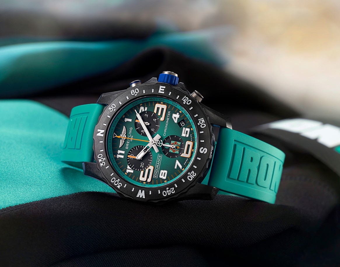 {generated} Montre Breitling Endurance Pro 44 Ironman 70.3 au bracelet turquoise et chiffres marqués, posée sur équipement sportif.