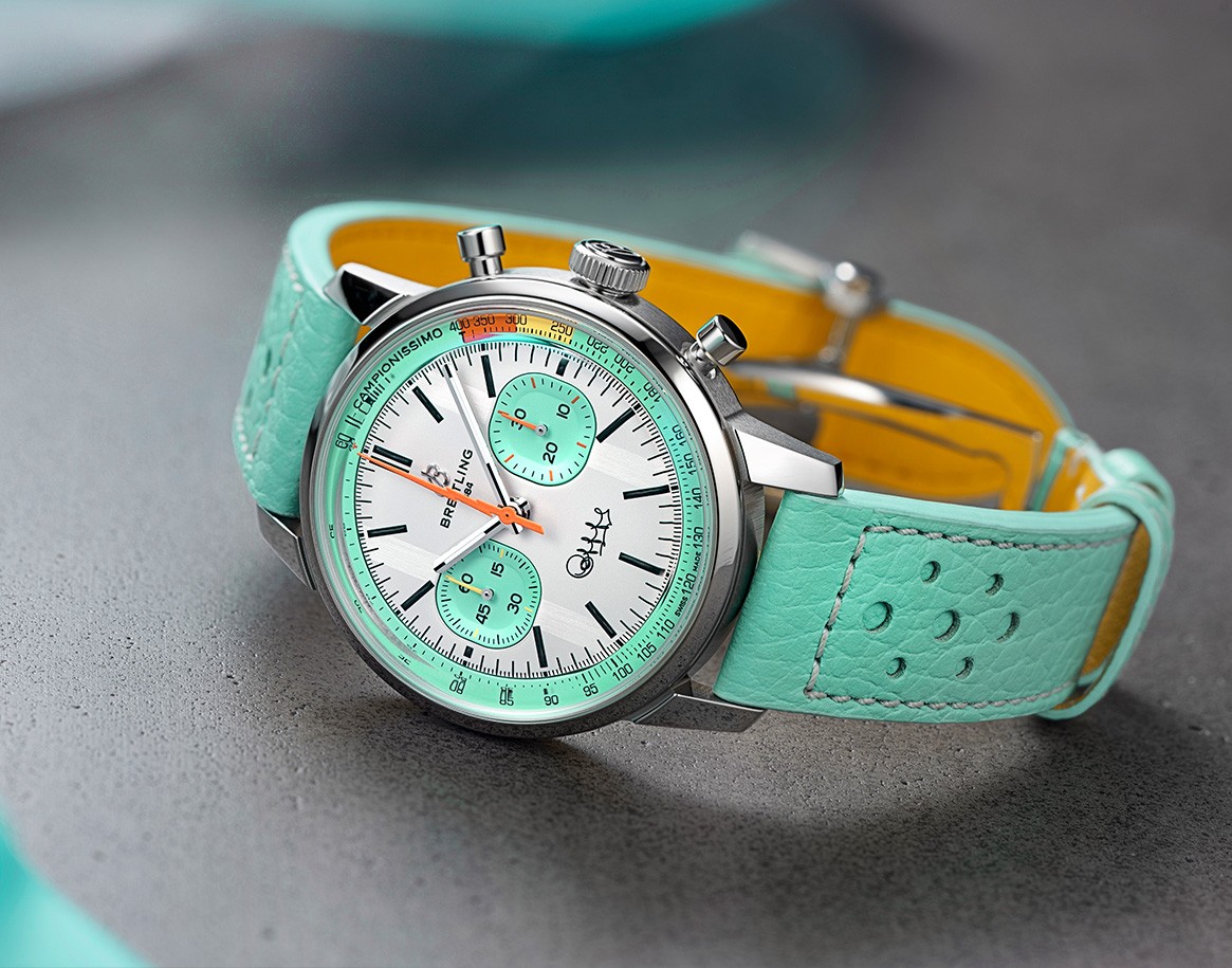 {generated} Relógio Breitling Bartali com pulseira de couro menta e mostrador branco com submostradores turquesa sobre superfície cinza