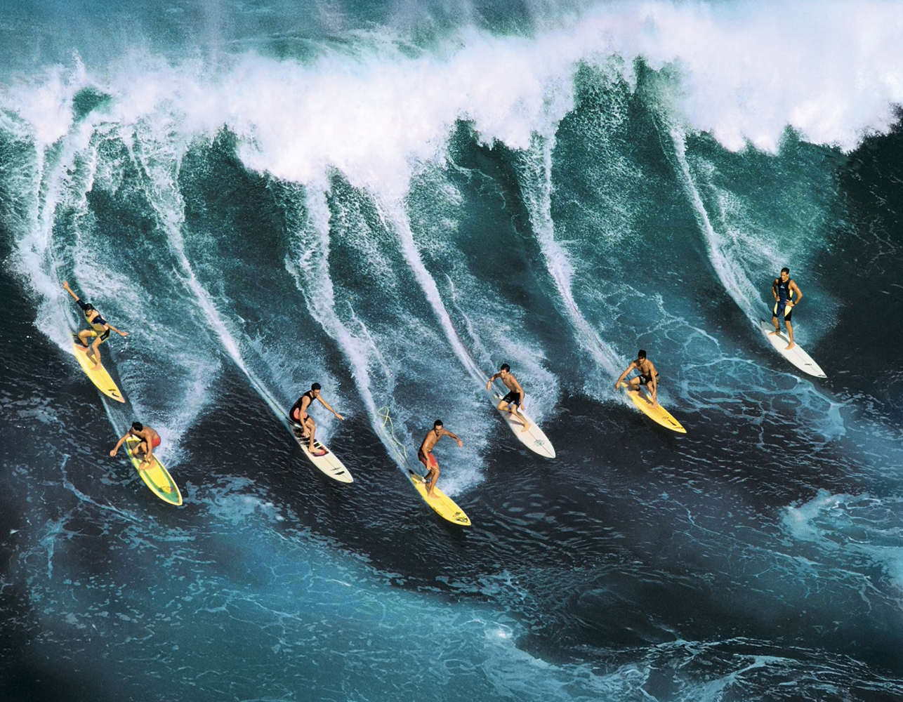 {generated} Surfisti affrontano una potente onda turchese, richiamando lo spirito dinamico dell’oceano che ispira la Breitling Superocean