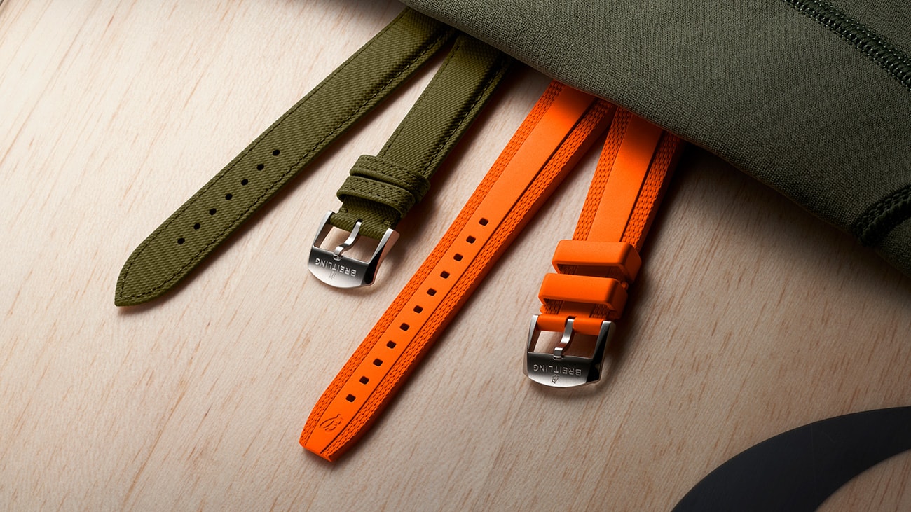 {generated} Breitling green fabric and orange rubber straps arranged on a wooden surface, highlighting colourful gifting options.