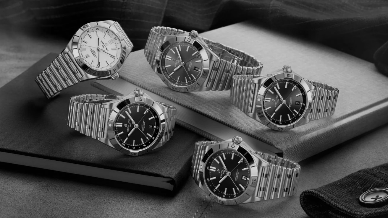 {generated} Breitling Chronomat watches arranged on books, showcasing polished steel cases and varied dials in a refined setting.