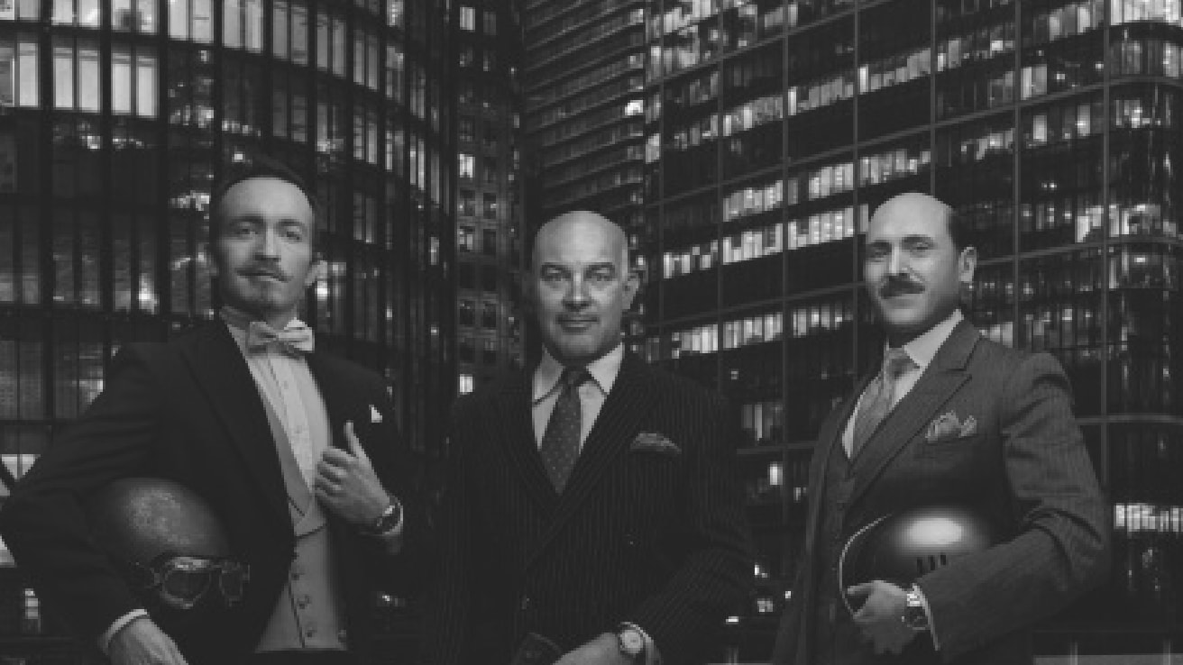 {generated} Three suited men holding helmets before a night city skyline, each wearing a Breitling watch to convey refined style