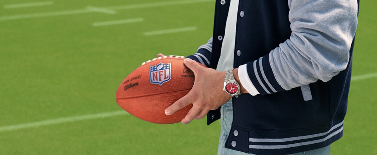{generated} Des gradins lumineux dominent le logo NFL au centre, avec un marquage Breitling bien visible le long de la ligne latérale.