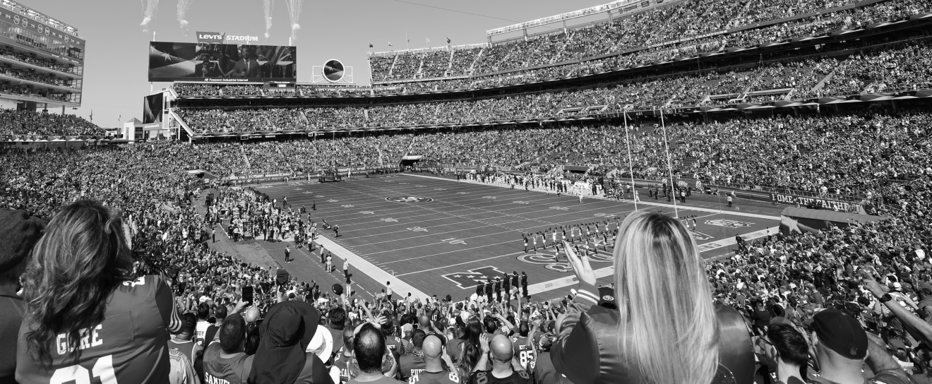 {generated} Breitling partnership scene showing a packed NFL stadium with fans overlooking the field as teams assemble before kickoff
