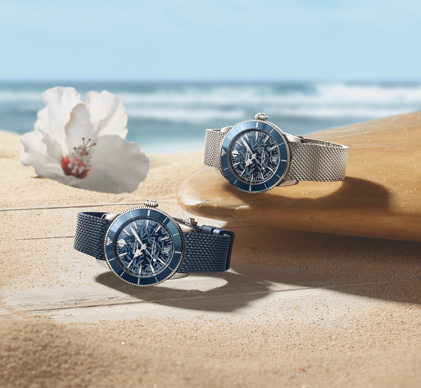 {generated} Breitling Superocean Heritage Kelly Slater watches with blue dials set on sandy beach beside a sunlit surfboard