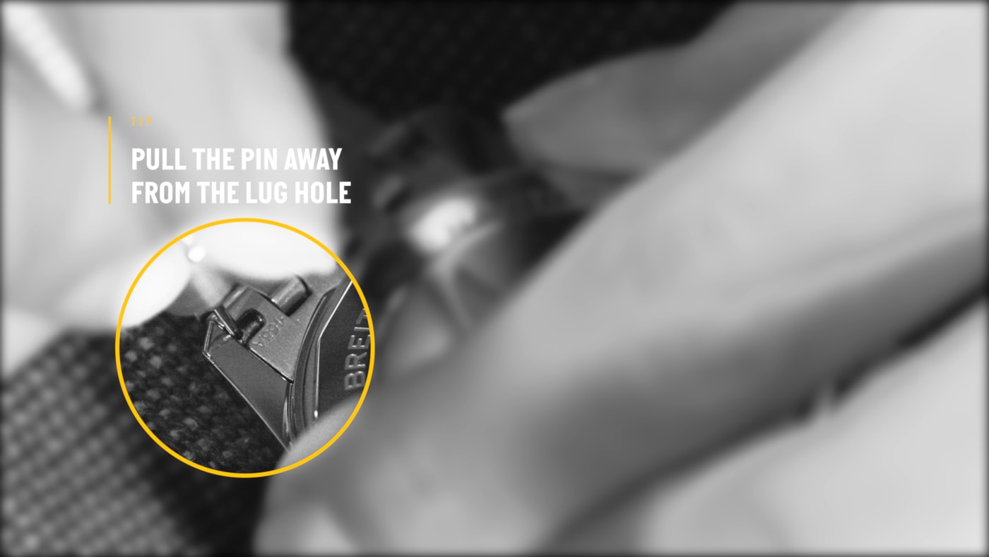 {generated} Крупный план рук, снимающих штифт ремешка Breitling, с акцентом на зоне ушек для чёткого показа этапа.