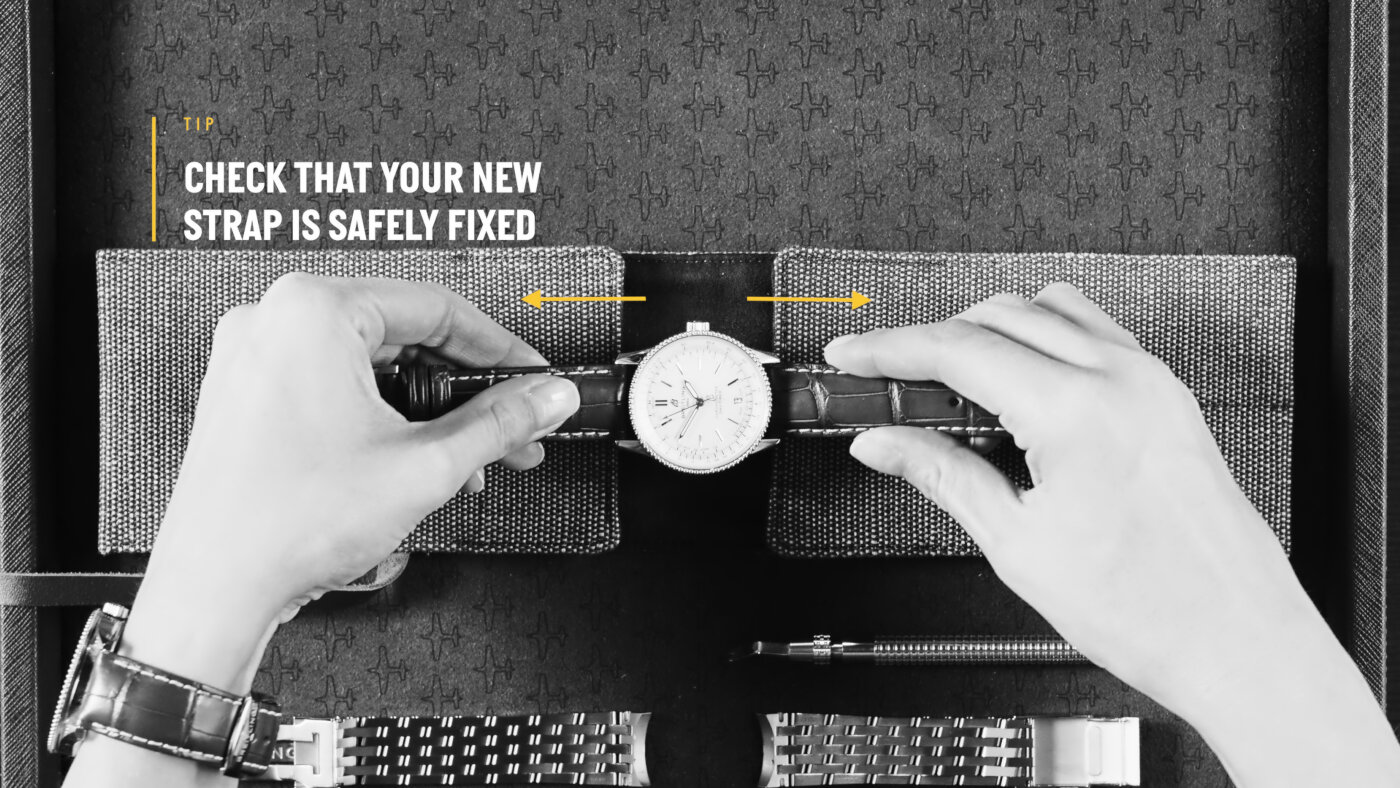 {generated} Руки проверяют часы Breitling, чтобы убедиться, что новый кожаный ремешок надежно закреплен, с инструментами и деталями рядом.