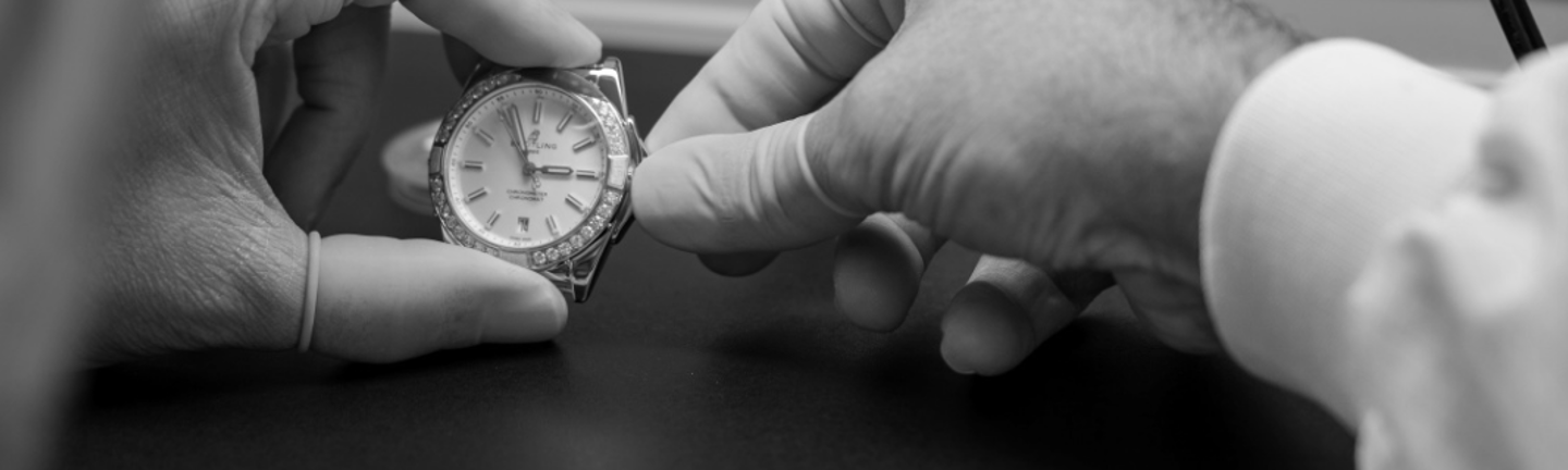 {generated} Technician’s gloved hands carefully inspecting a Breitling watch during a precision service procedure.