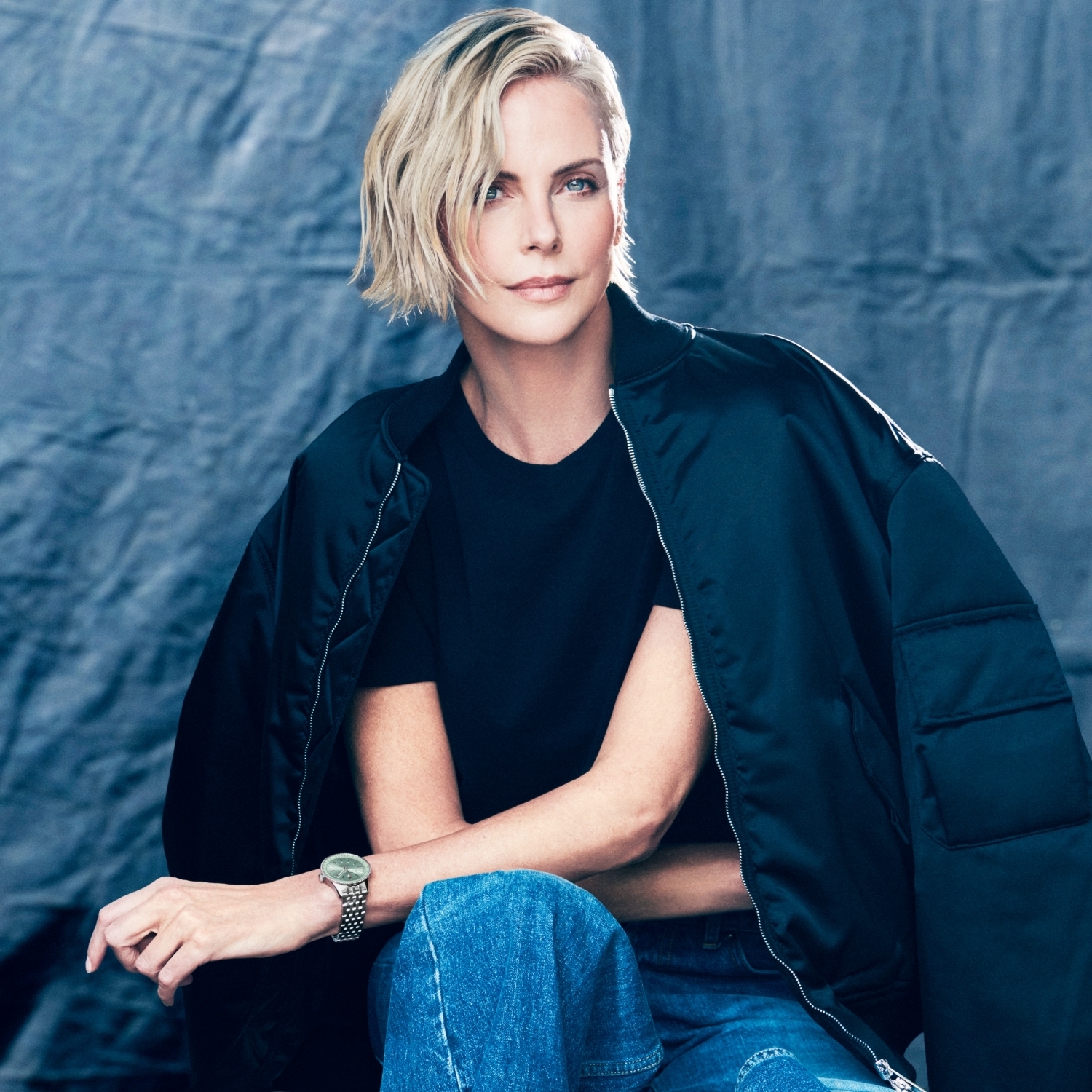 {generated} 身著深色服裝的女性在柔光與電影感背景的攝影棚中展現，散發細緻且自信的氣息。