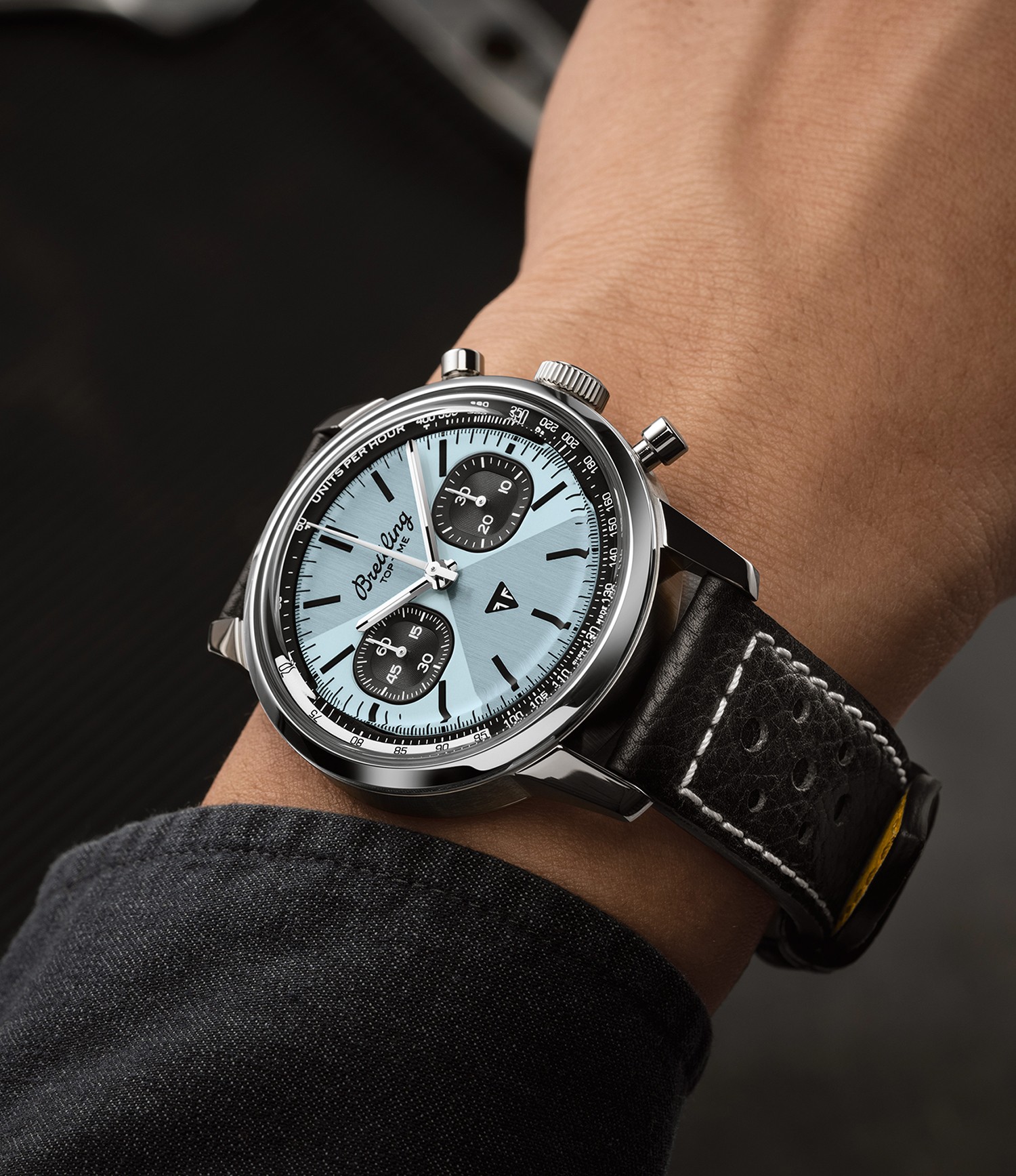 {generated} Breitling Top Time Triumph au cadran bleu glacé et bracelet noir en cuir présenté au poignet pour souligner son style raffiné