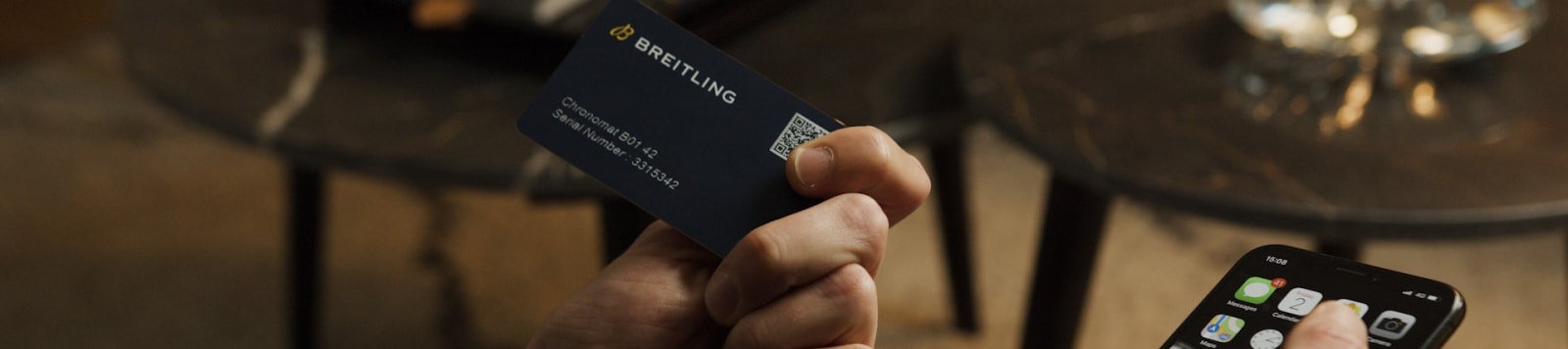 {generated} スマートフォン操作と併せてBreitlingのデジタルパスポートカードを持つ様子で、安全な所有確認を強調。