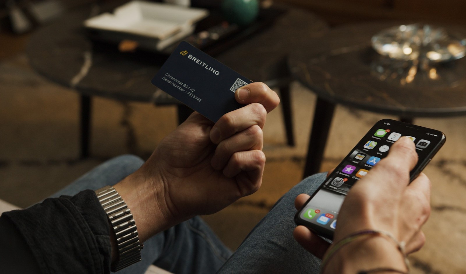 {generated} スマートフォン操作と併せてBreitlingのデジタルパスポートカードを持つ様子で、安全な所有確認を強調。