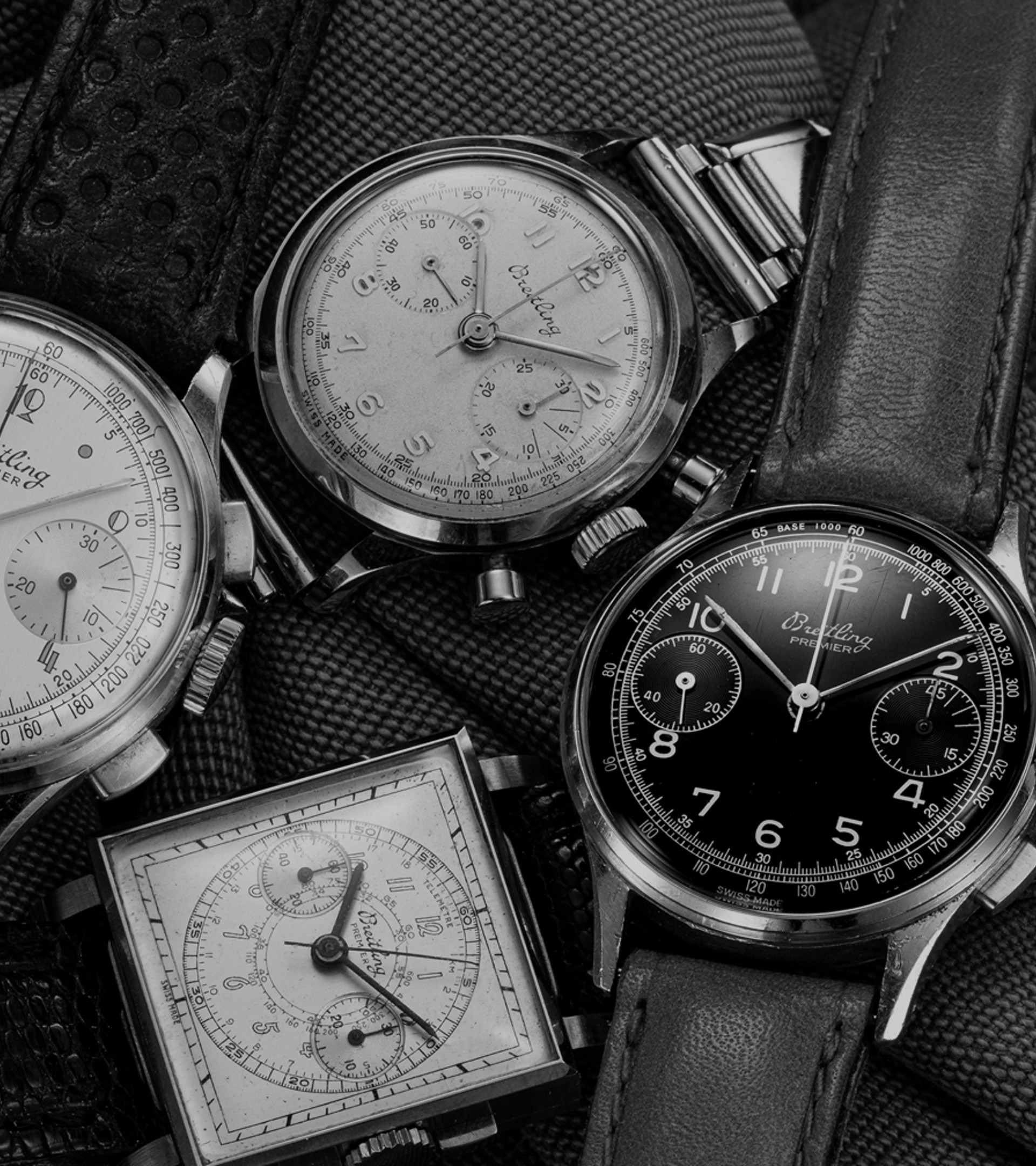 {generated} Vintage Breitling Premier chronographs displayed on textured fabric, highlighting classic dials, cases, and leather straps