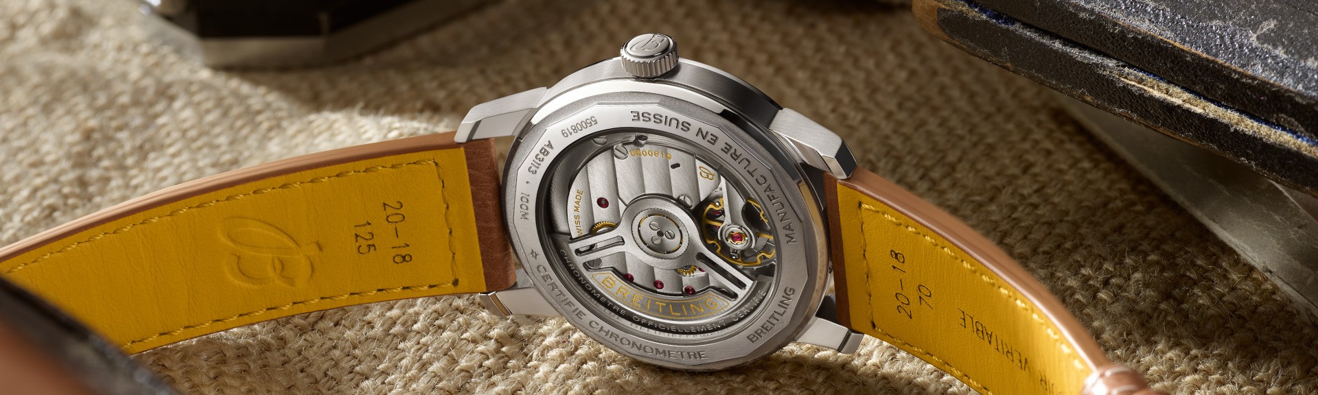 {generated} Breitling Caliber B31由背面展示機械機芯結構，同時呈現皮革錶帶細節。