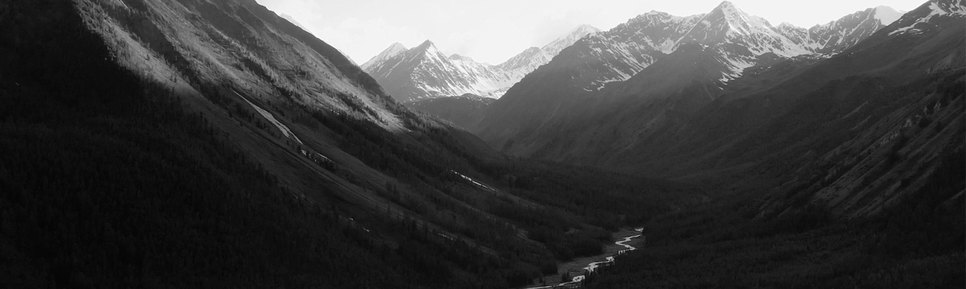{generated} Expansive mountain valley and winding river highlighting nature’s scale and Breitling’s commitment to sustainability.