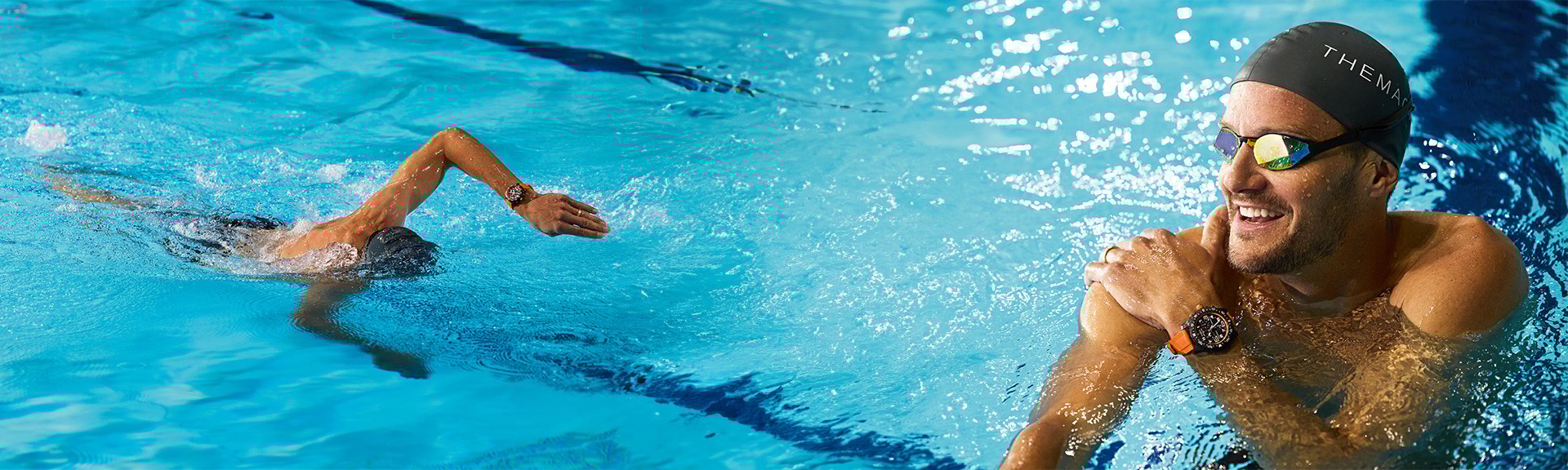 {generated} A swimmer wearing a Breitling watch with an orange strap glides through a bright pool before pausing at the water’s edge