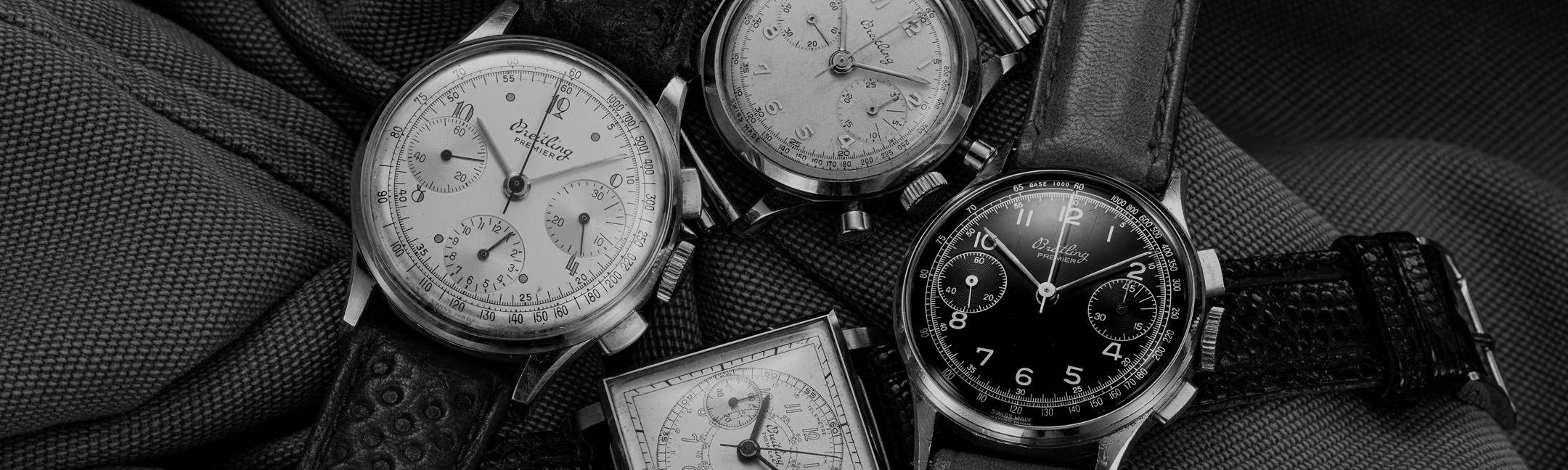 {generated} Vintage Breitling Premier chronographs displayed on textured fabric, highlighting classic dials, cases, and leather straps