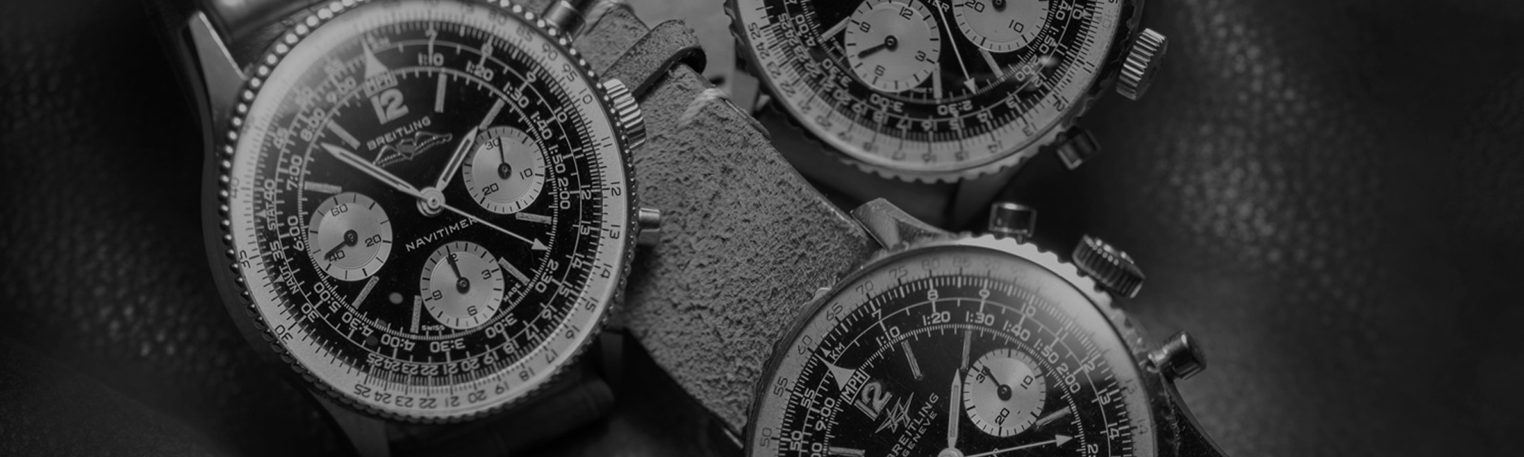 {generated} ヴィンテージのブレイトリング ナビタイマー3本が黒い文字盤とクラシックなクロノグラフ設計を際立てる詳細なクローズアップで並ぶ