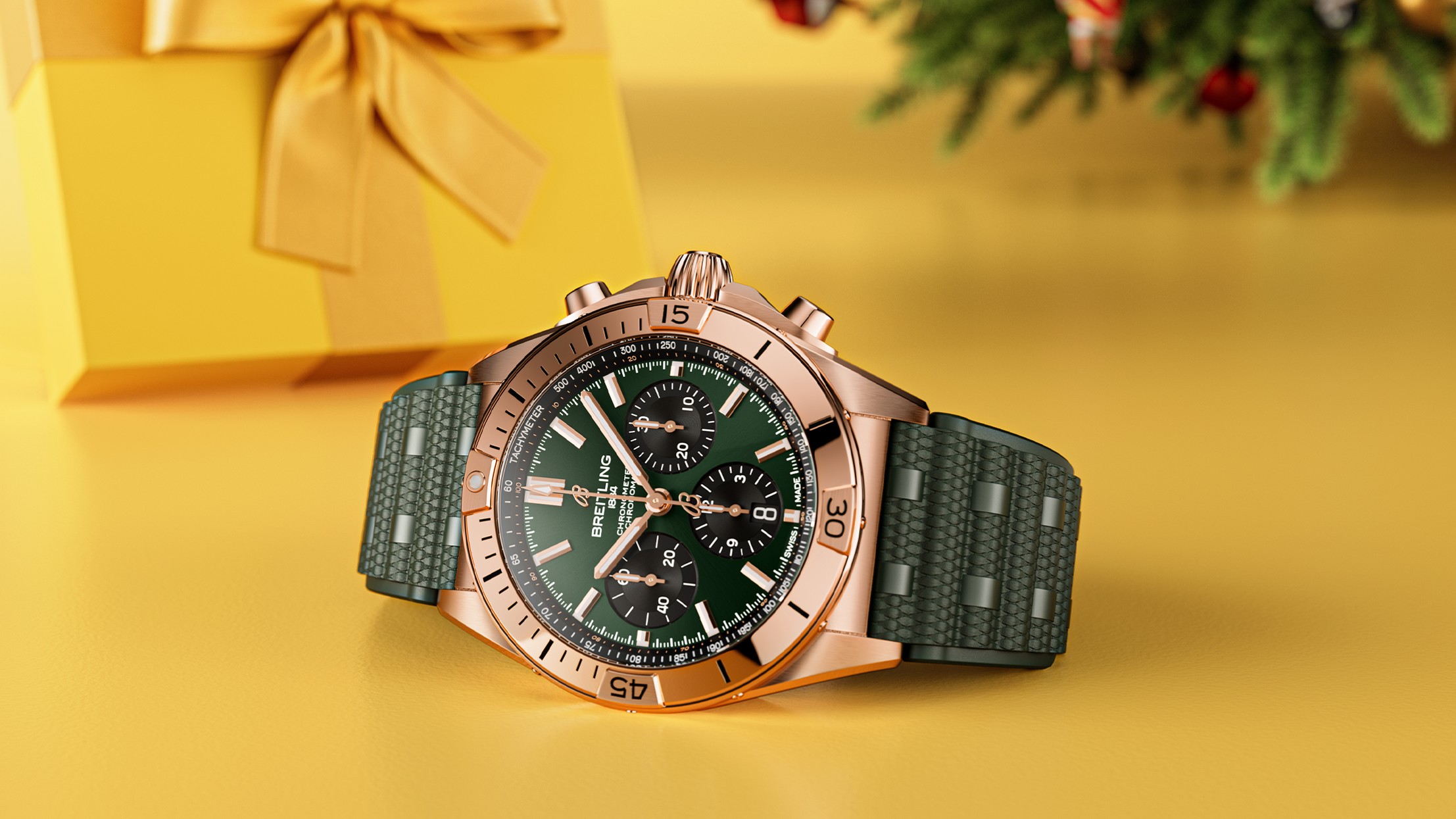 {generated} Breitling Chronomat with green dial and rubber strap set beside a yellow gift box in a warm festive holiday scene