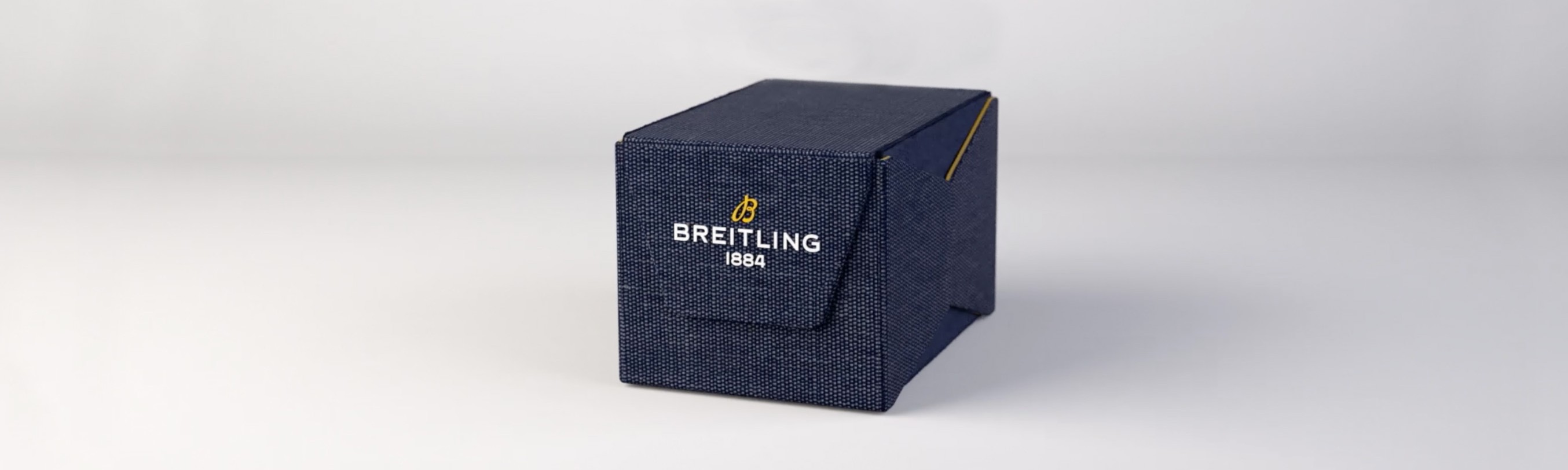 {generated} A navy textured box displaying the Breitling logo, highlighting the brand’s refined watch packaging against a clean backdrop.