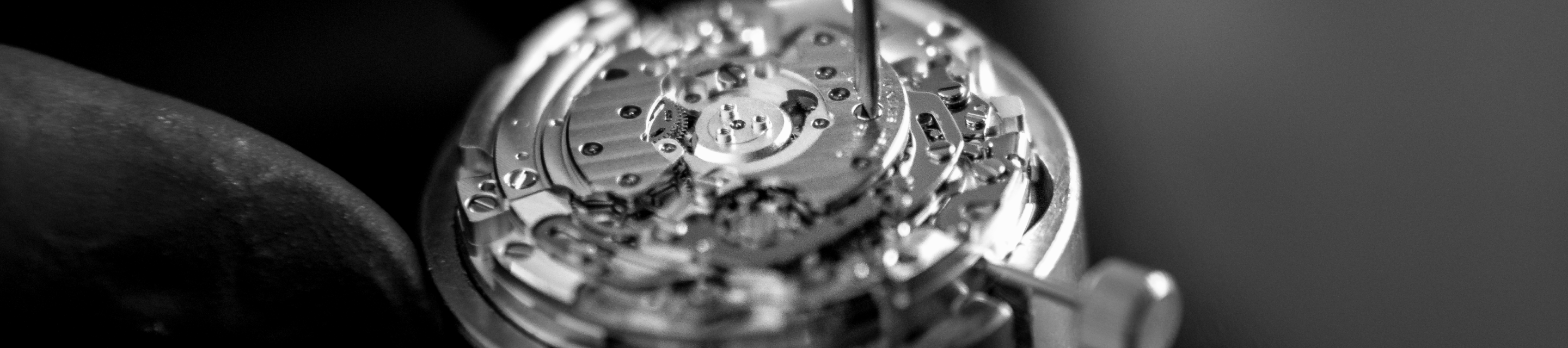 {generated} 時計職人がブライトリングのムーブメントを調整する様子を捉えた接写で、精巧な部品と精密な計時技術を強調