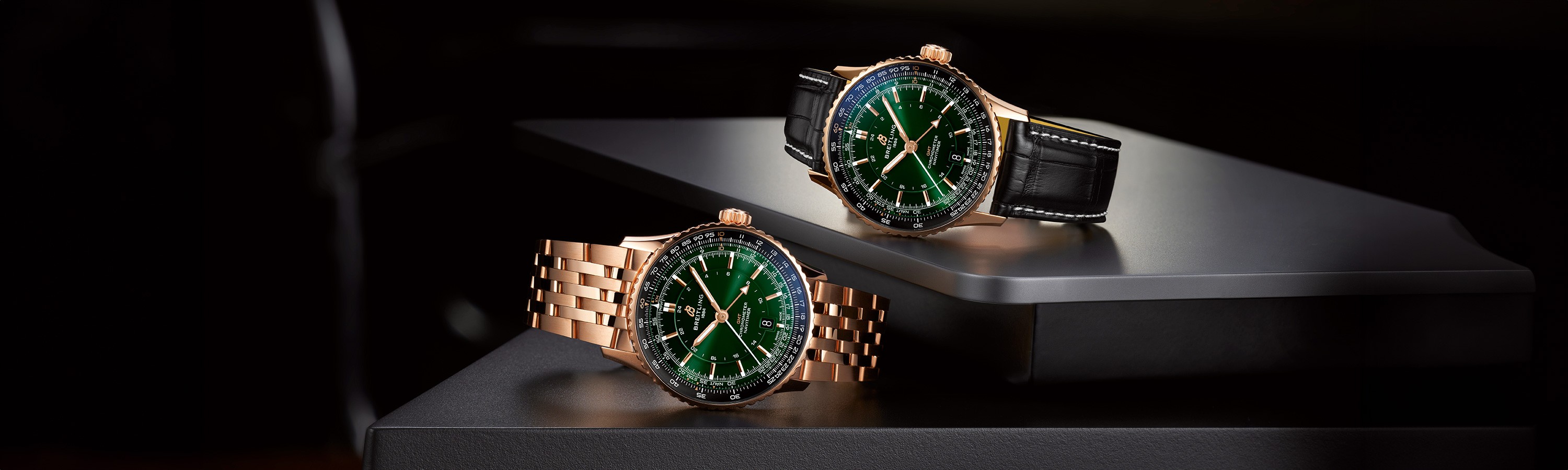 {generated} 兩款金色Breitling Navitimer綠色錶盤腕錶，以金屬與皮革錶帶呈現，陳列在深色表面上。