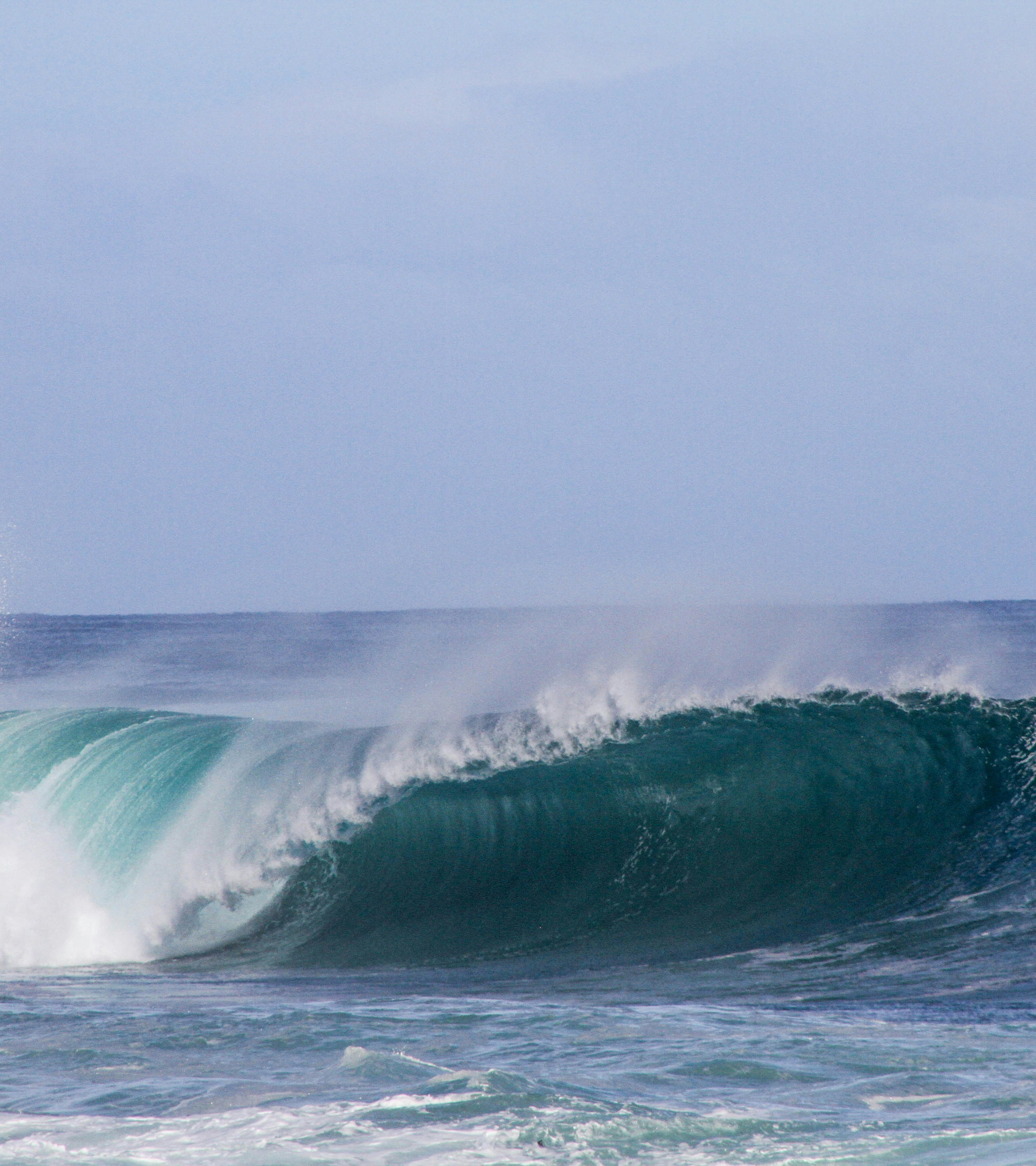 {generated} Powerful turquoise wave curling beneath a bright sky, capturing ocean energy and the dynamic Surfrider spirit