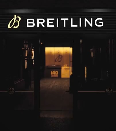 {generated} Breitling storefront with illuminated logo and warm interior highlighting the 140th anniversary limited editions display.